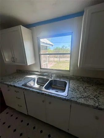 a kitchen with stainless steel appliances granite countertop a sink a stove and a granite counter tops with a window