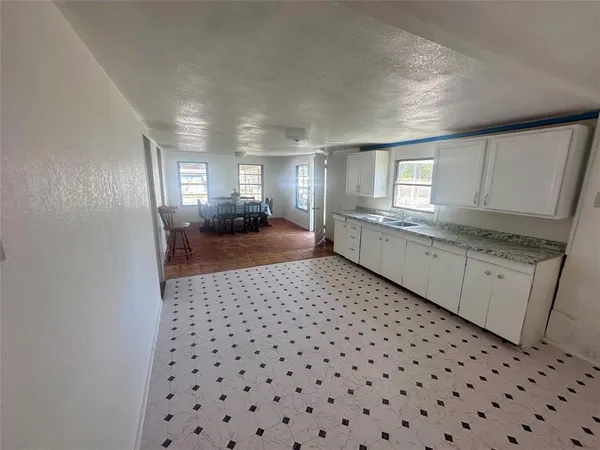 a large kitchen with a sink a window and stainless steel appliances