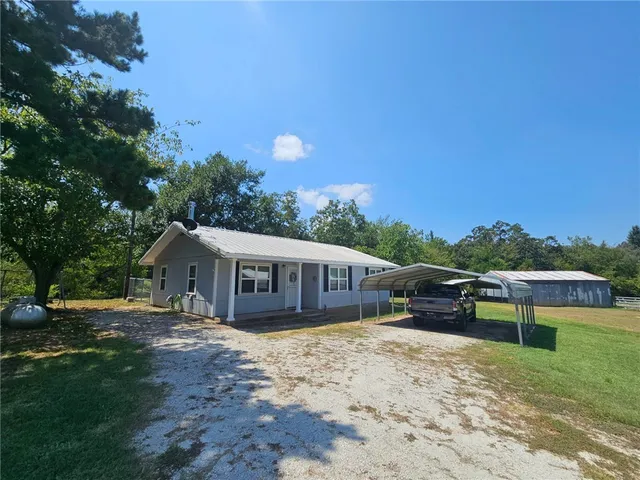 a view of a house with a yard and sitting area