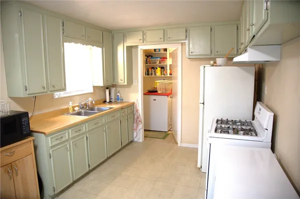 a kitchen with a refrigerator and a stove top oven