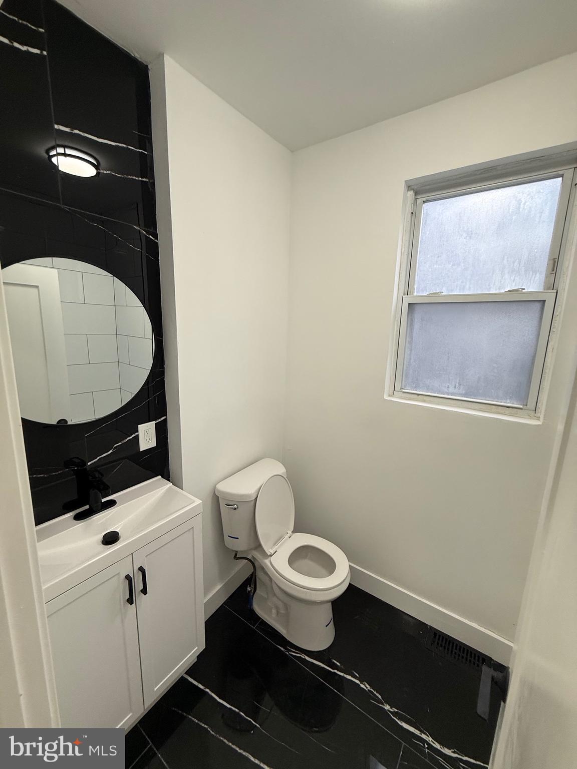5908 Christian Street Philadelphia, PA 19143 - Photo 19 of 41 a bathroom with a toilet a sink and mirror
