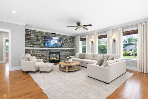a living room with fireplace furniture and a large window
