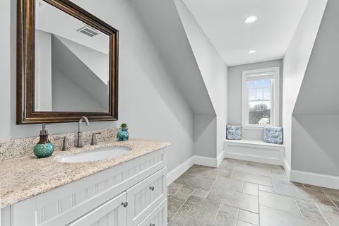 a bathroom with a granite countertop sink a mirror and a bathtub