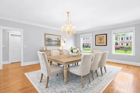 a view of a dining room with furniture a rug and wooden floor
