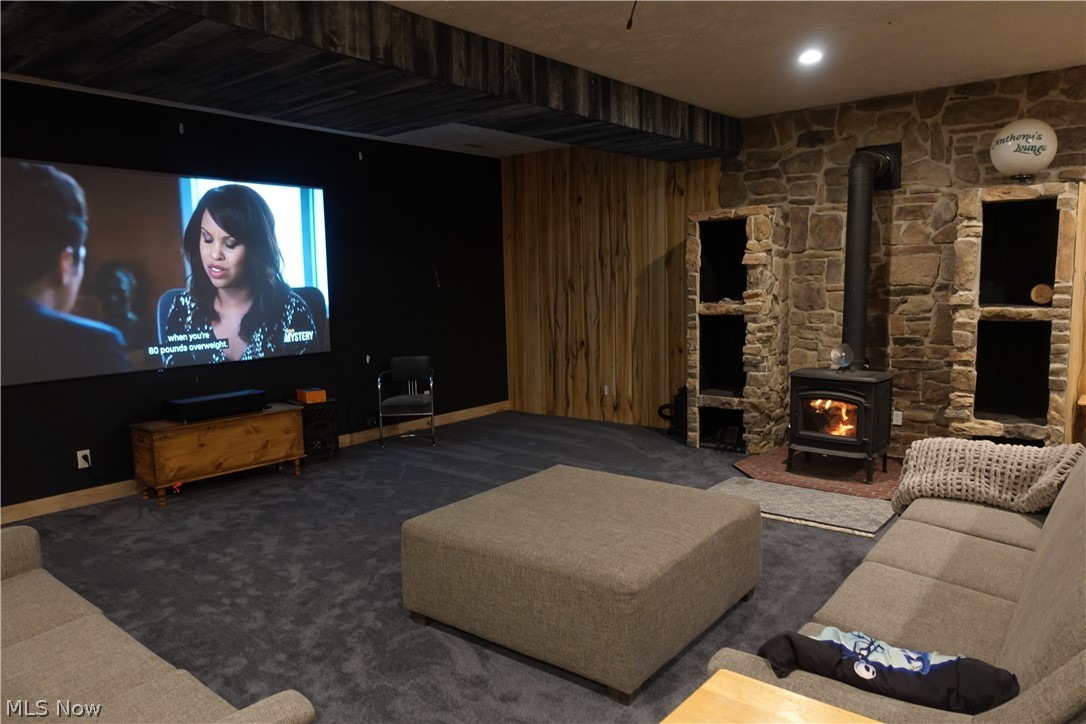 15488 Hatfield Road Rittman, OH 44270 - Photo 27 of 36 Carpeted home theater room with wood walls and a wood stove