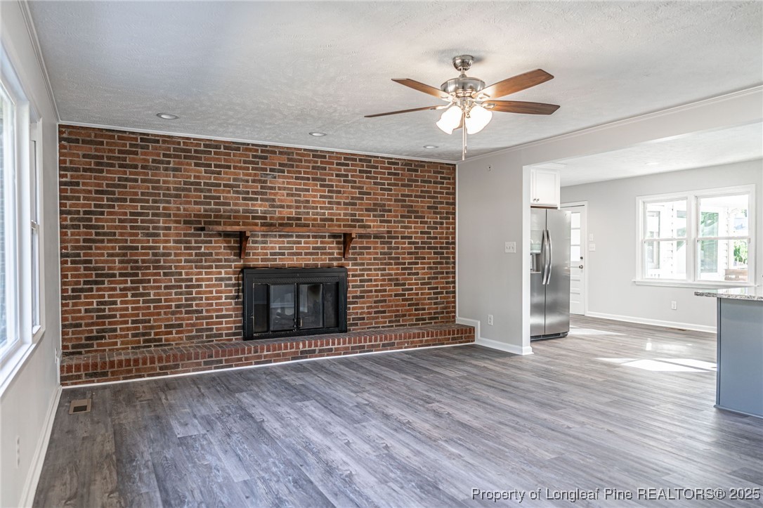 255 Foxcroft Road Whispering Pines, NC 28327 - Photo 4 of 31 a view of an empty room with wooden floor and a fireplace