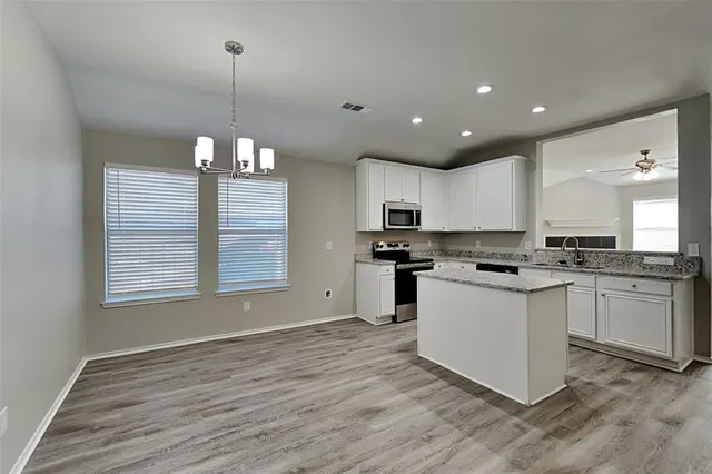 a kitchen with a refrigerator sink and cabinets