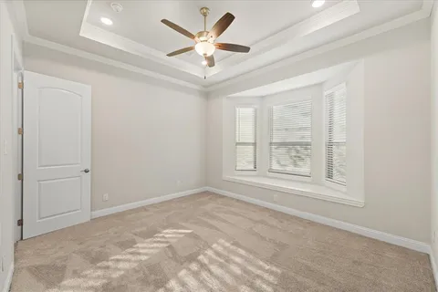 an empty room with windows and ceiling fan