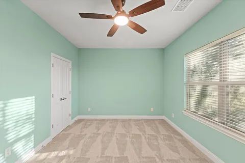 a view of an empty room with a window and a fan