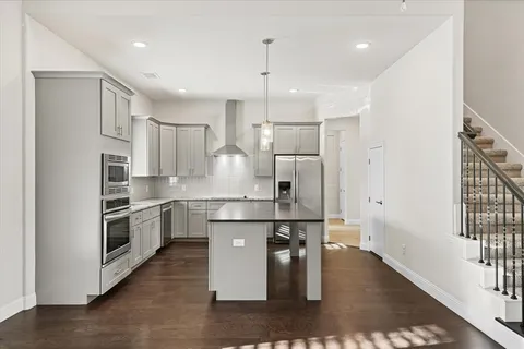 a kitchen with kitchen island white cabinets and stainless steel appliances