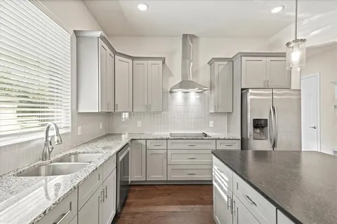 a kitchen with a sink dishwasher a stove and a refrigerator with wooden floor