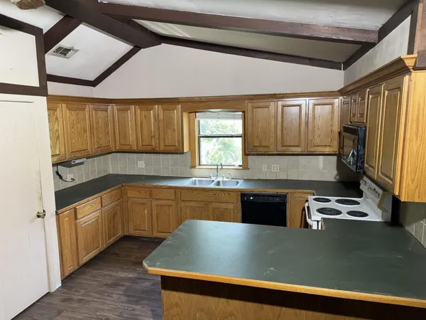 a kitchen with granite countertop a sink window and refrigerator