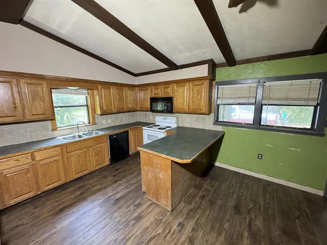 a kitchen with wooden floors and wooden cabinets