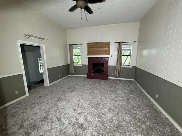 a view of empty room with a fireplace and windows