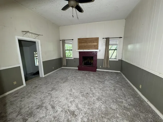 a view of empty room with a fireplace and windows