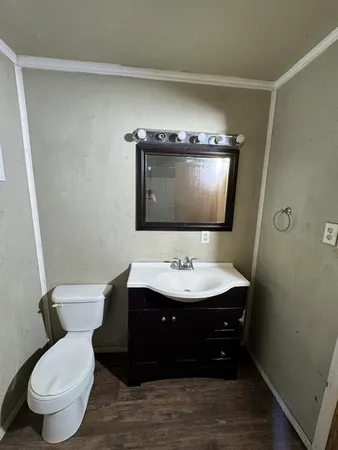 a bathroom with a toilet sink and mirror