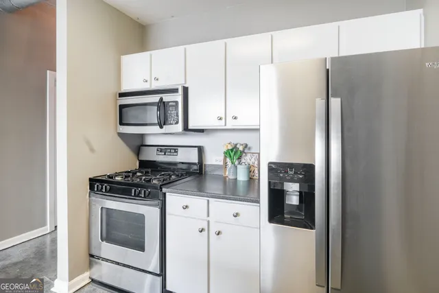 a kitchen with stainless steel appliances white cabinets and a stove