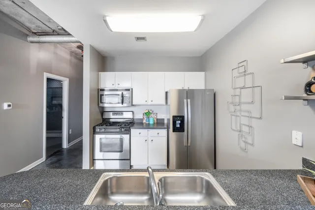 a kitchen with stainless steel appliances granite countertop a refrigerator and a sink