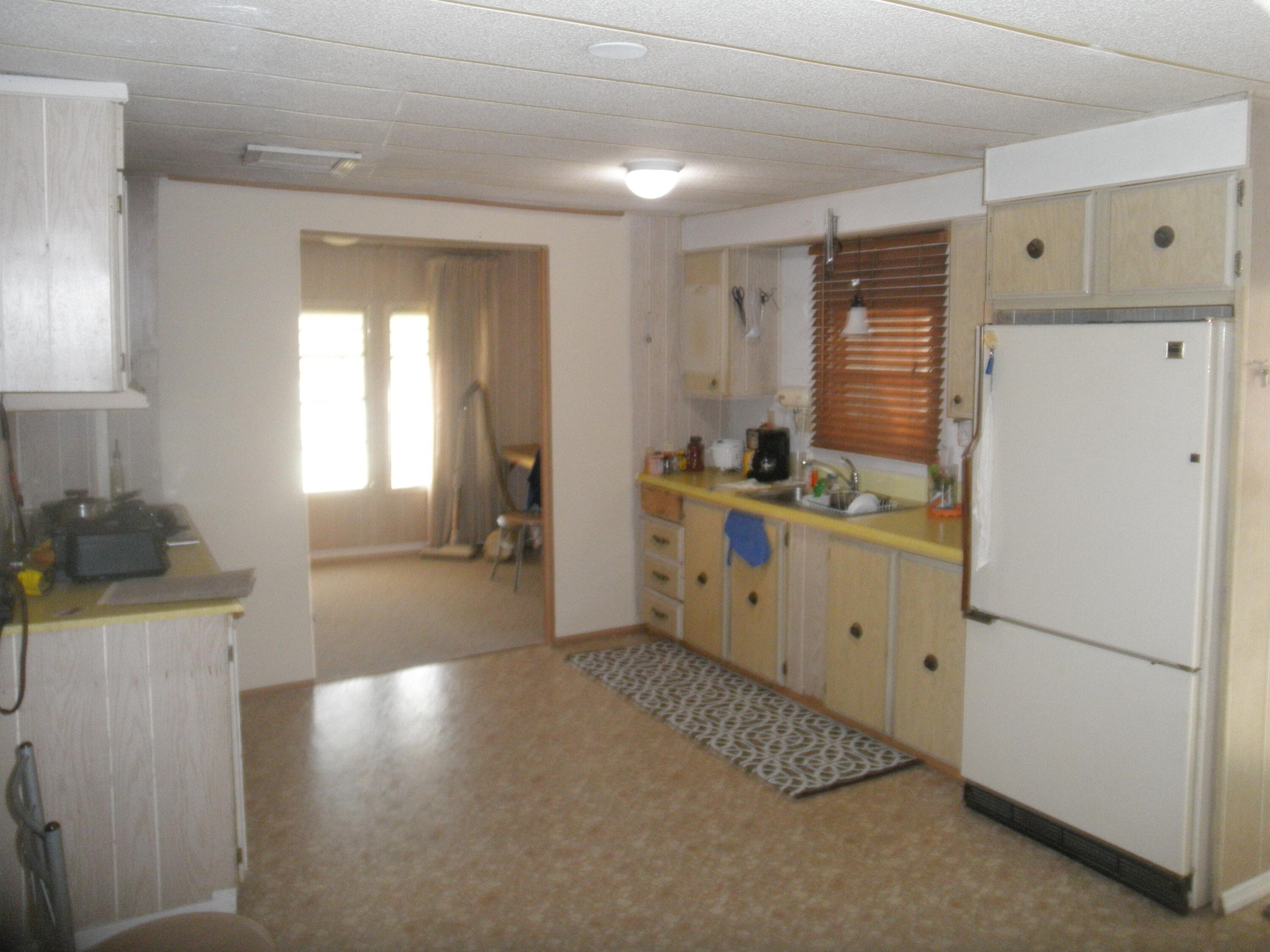 4544 Sunset Ranch Road West Palm Beach, FL 33415 - Photo 2 of 10 a kitchen with a refrigerator a stove top oven a counter space and a window