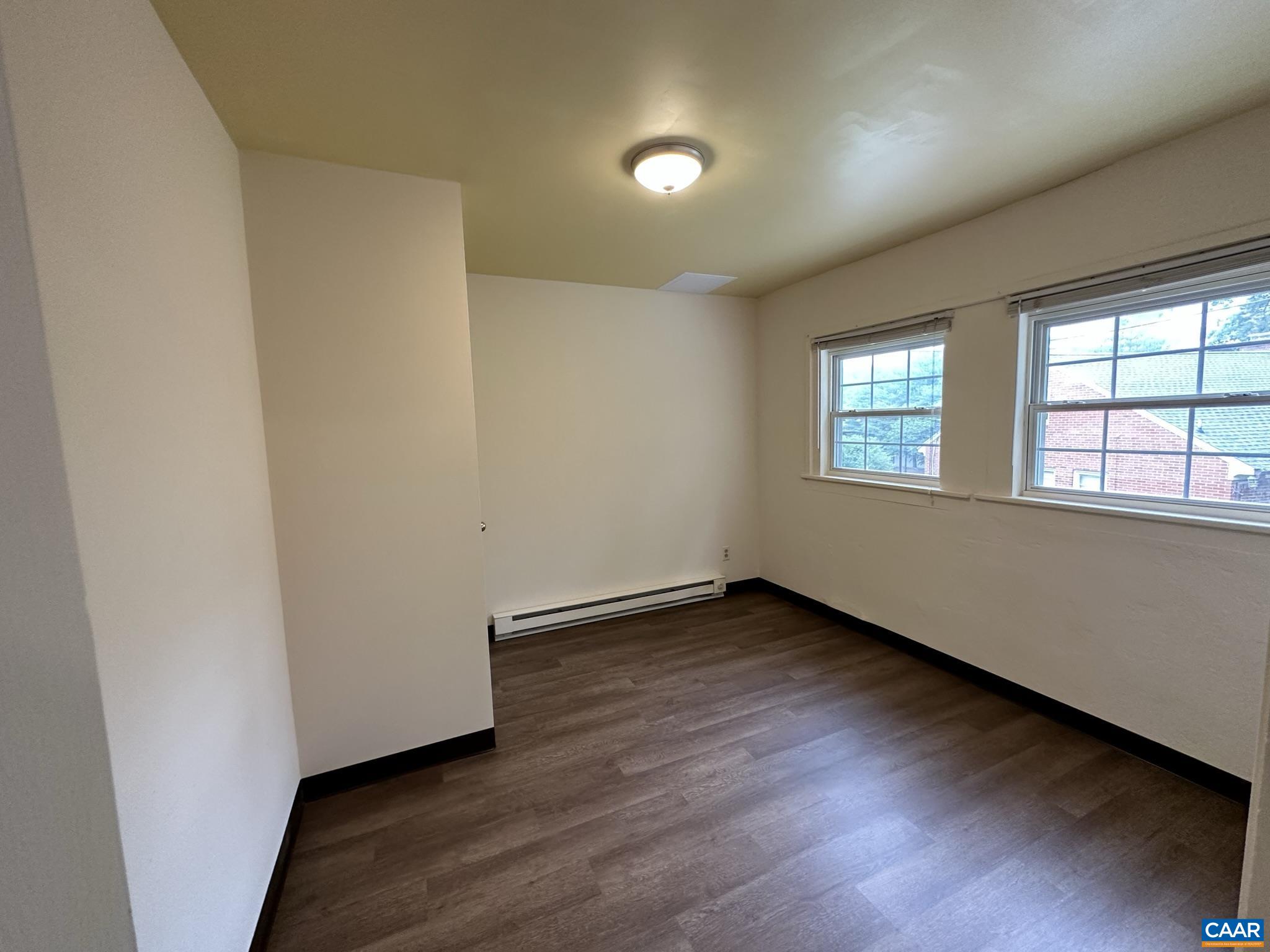 104 Dunova Court, Unit 2 Charlottesville, VA 22903 - Photo 5 of 8 an empty room with wooden floor and windows