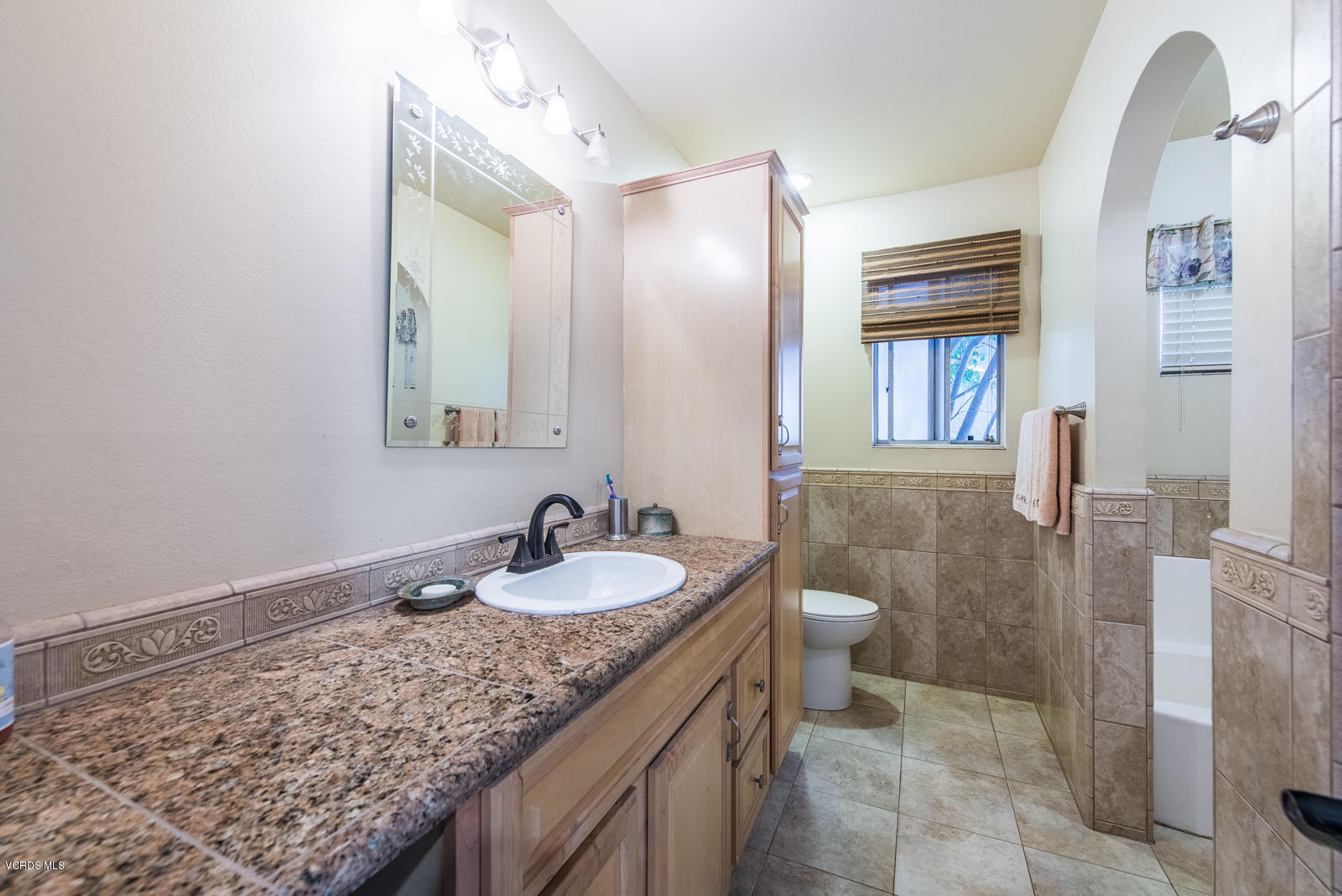 1610 Rambling Road Simi Valley, CA 93065 - Photo 14 of 26 a bathroom with a granite countertop sink and a mirror