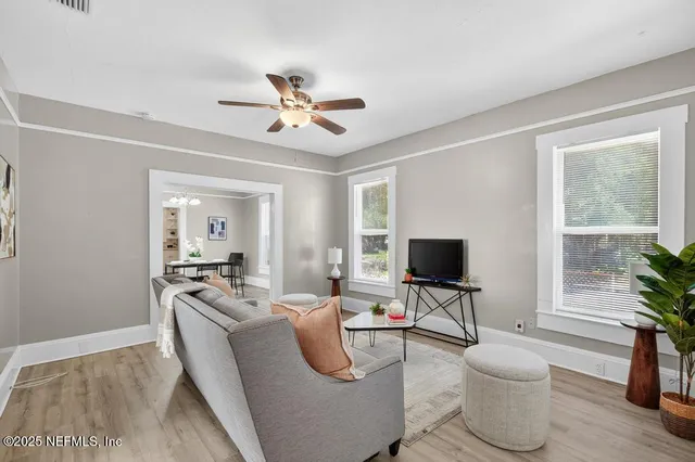 a living room with furniture a window and a flat screen tv