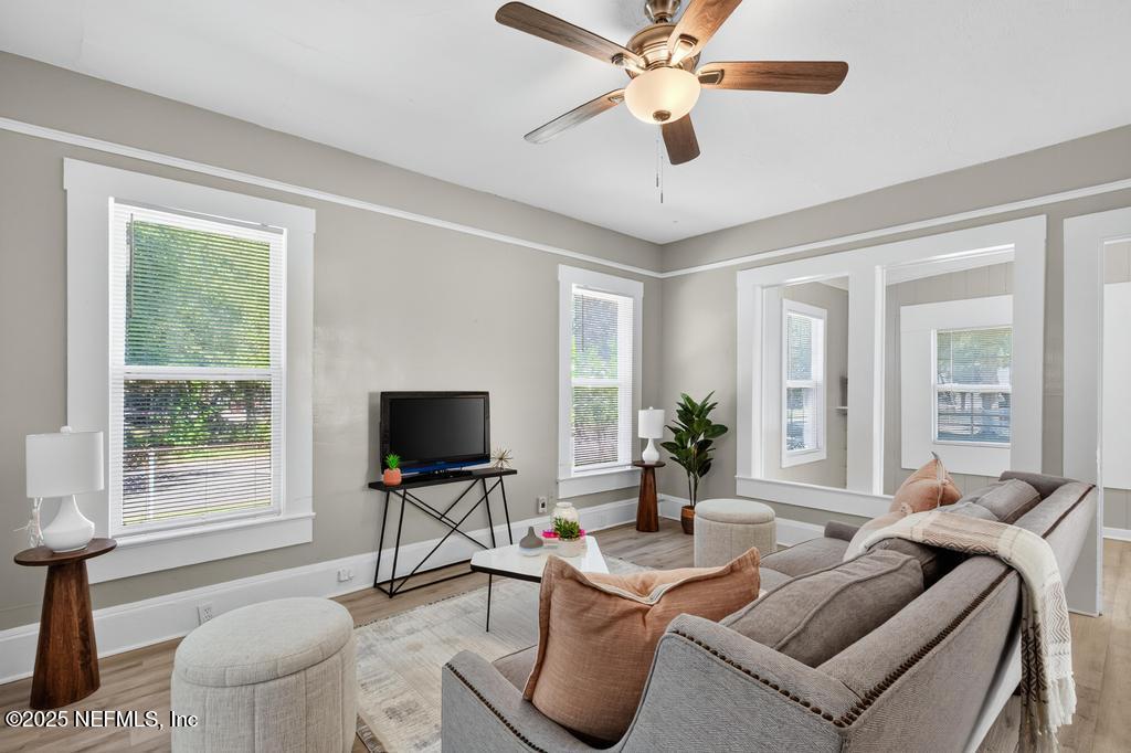 a living room with furniture a flat screen tv and a large window