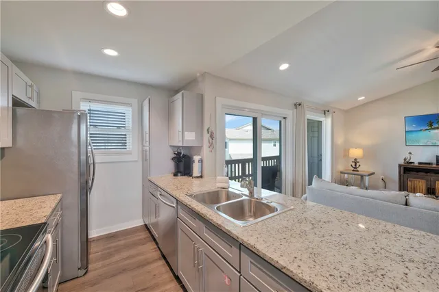 a kitchen with stainless steel appliances granite countertop a refrigerator and a sink
