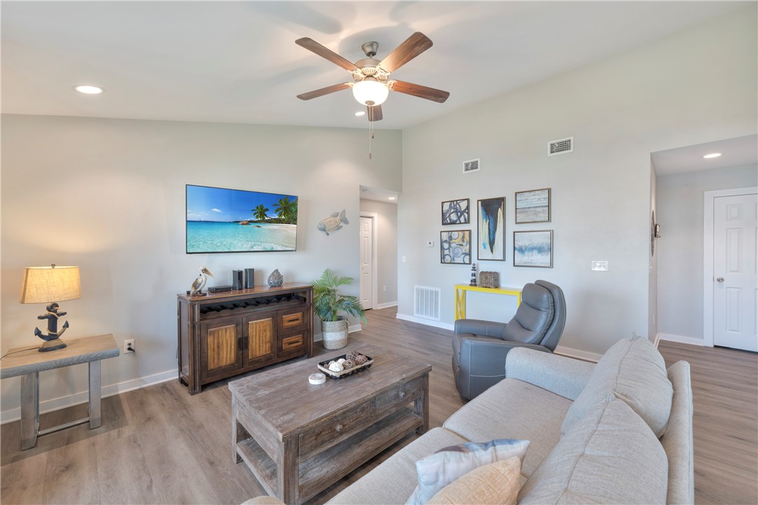 230 Cut-Off Road, Unit 204 Port Aransas, TX 78373 - Photo 13 of 37 a living room with furniture a fireplace and a potted plant