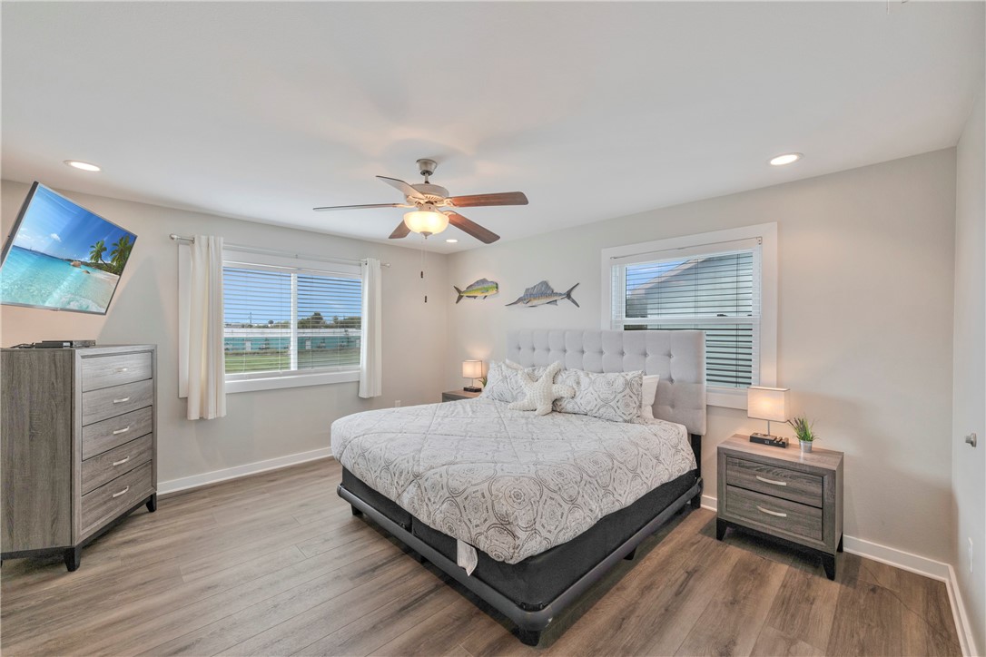 230 Cut-Off Road, Unit 204 Port Aransas, TX 78373 - Photo 20 of 37 a bedroom with a bed and a chandelier