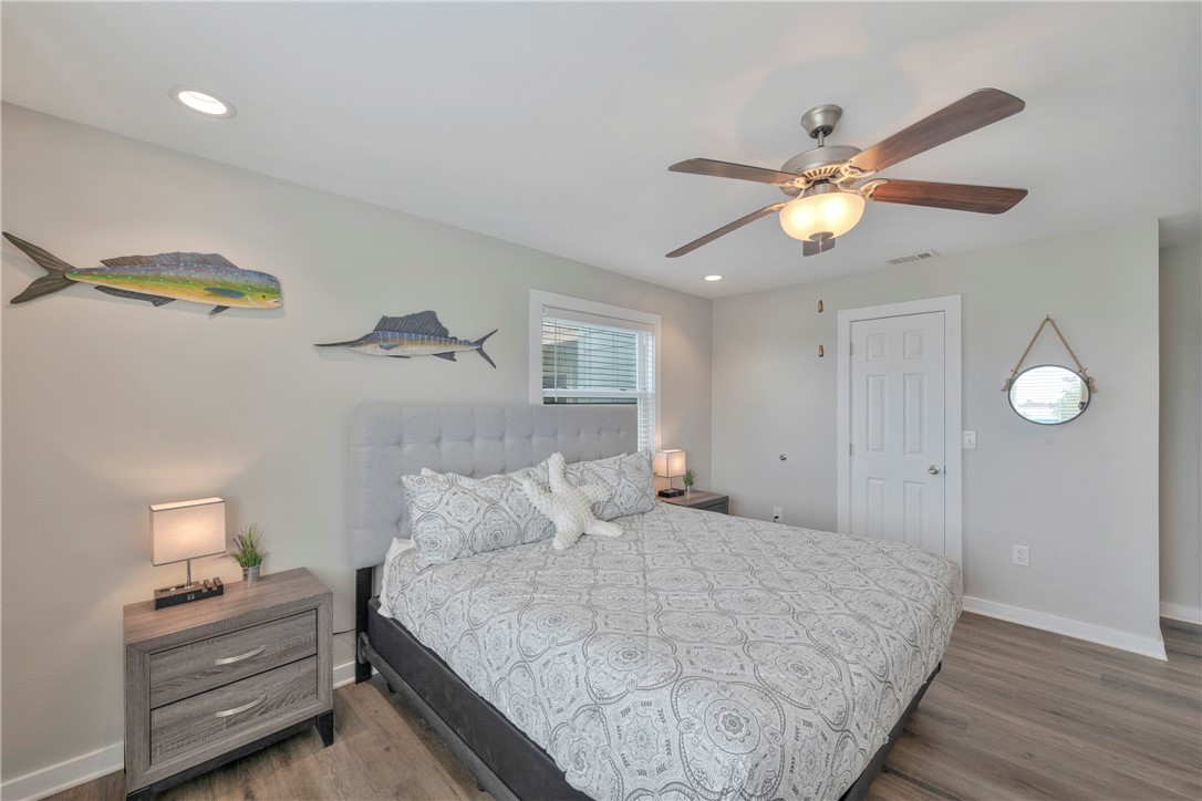 230 Cut-Off Road, Unit 204 Port Aransas, TX 78373 - Photo 21 of 37 a bedroom with a bed and a chandelier