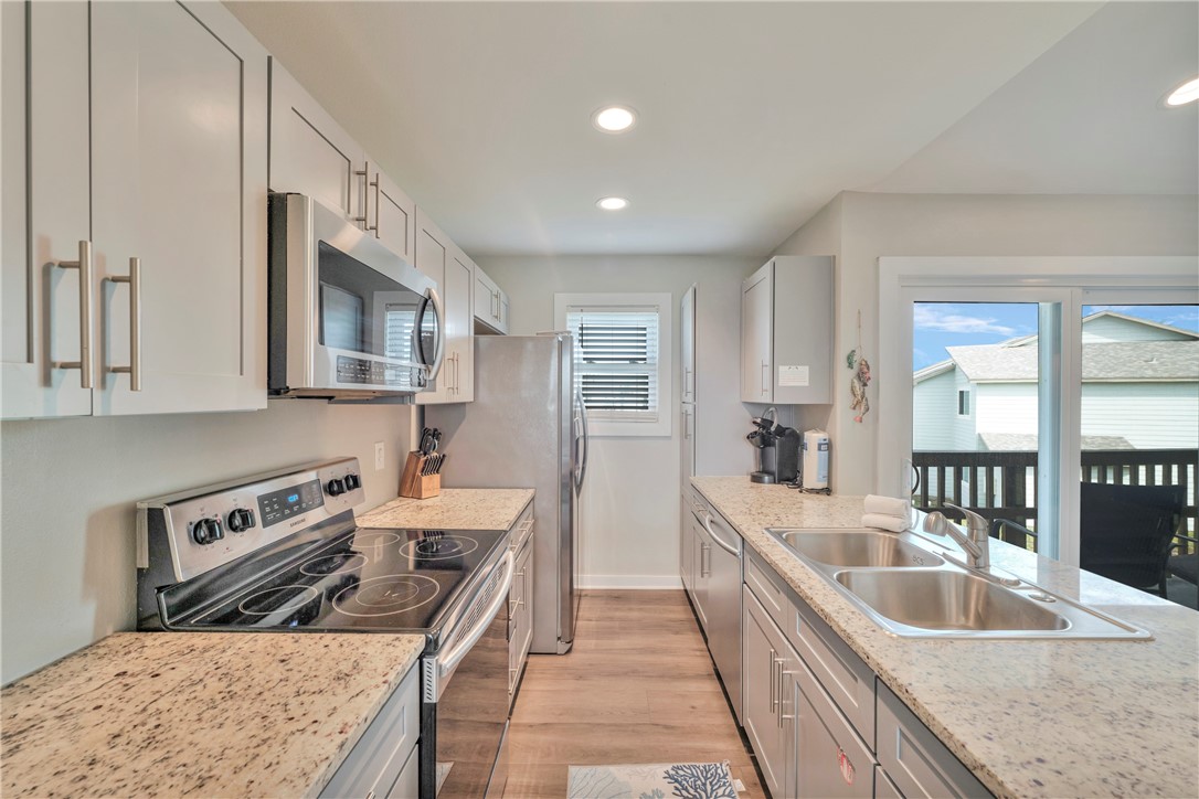 230 Cut-Off Road, Unit 204 Port Aransas, TX 78373 - Photo 9 of 37 a kitchen with stainless steel appliances granite countertop a sink stove and refrigerator