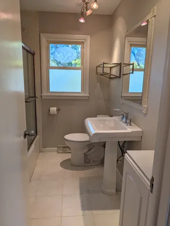a bathroom with a sink mirror and toilet