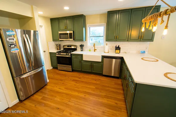 a kitchen with stainless steel appliances granite countertop a refrigerator stove and sink