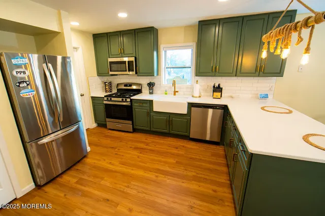 a kitchen with stainless steel appliances granite countertop a refrigerator stove and sink
