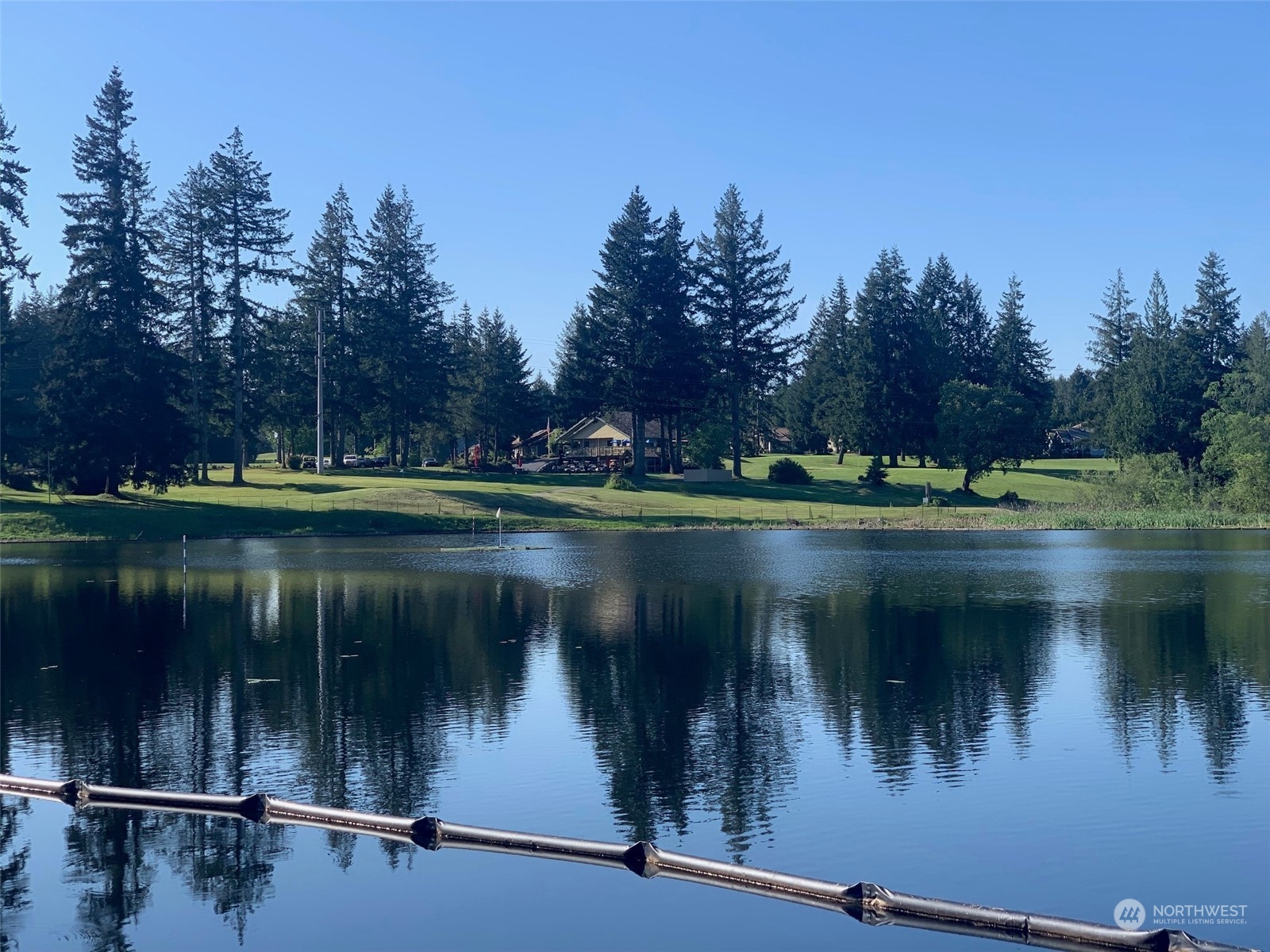 240 East Channel Drive Allyn, WA 98524 - Photo 25 of 33 a view of a lake with a yard and a wooden fence