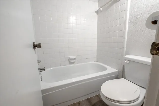 a white toilet sitting next to a bath tub