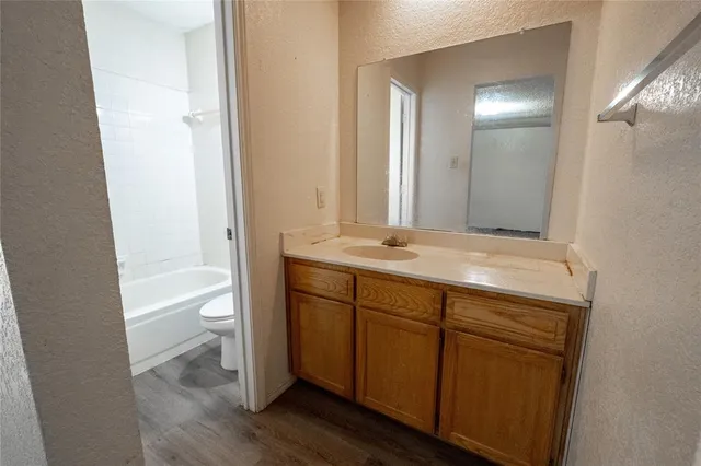 a bathroom with a sink a toilet and a large mirror