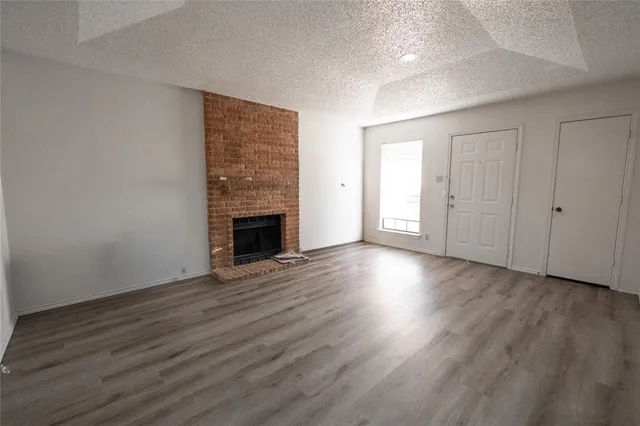 an empty room with wooden floor and fireplace