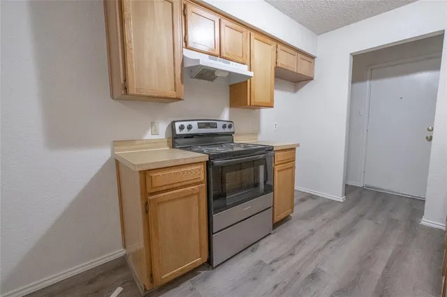 a kitchen with stainless steel appliances wooden floor sink and wooden cabinets