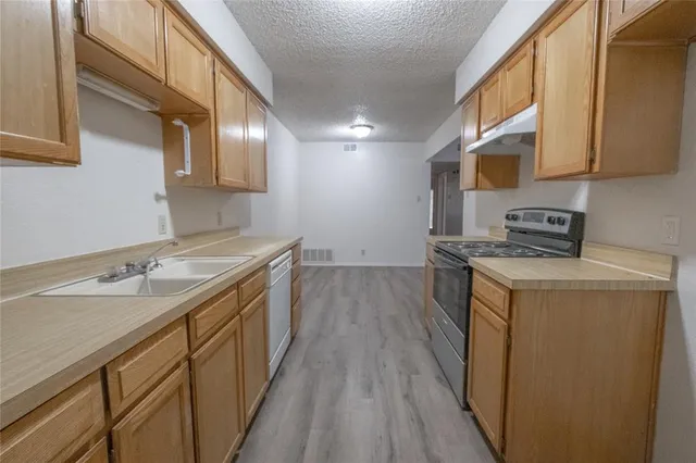 a kitchen with a sink stove and cabinets