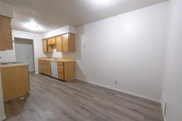 a view of a kitchen with a sink a refrigerator and wooden floor