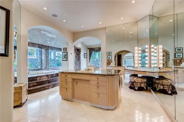 a bathroom with a granite countertop shower a mirror and a sink