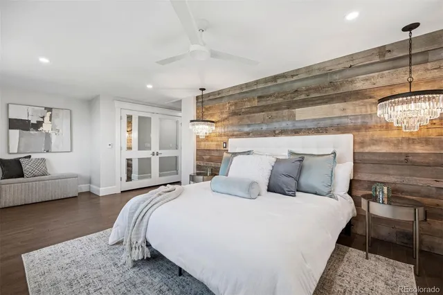 a bedroom with a large bed and wooden floor
