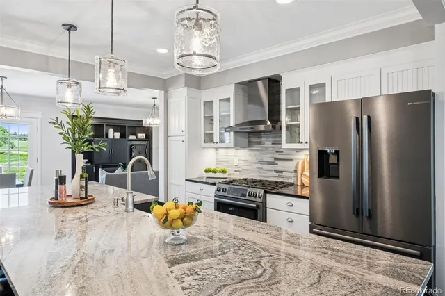 a kitchen with stainless steel appliances kitchen island granite countertop a refrigerator a stove a sink dishwasher and a dining table with wooden floor