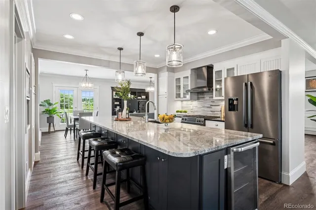 a kitchen with stainless steel appliances a dining table chairs and refrigerator