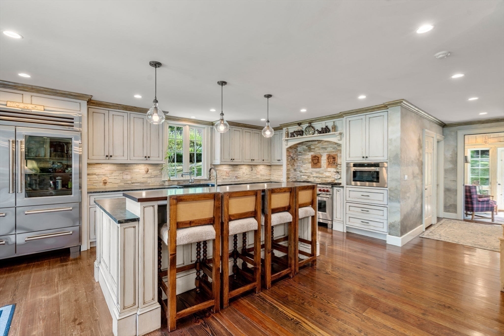 157 Centre Street Dover, MA 02030 - Photo 7 of 42 a kitchen with stainless steel appliances kitchen island granite countertop a stove a sink and a refrigerator