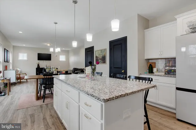 a large kitchen with kitchen island a counter top space a sink stainless steel appliances and cabinets