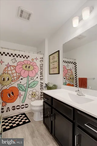 a bathroom with a sink toilet and painting on the wall