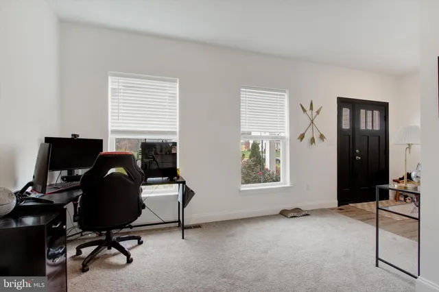 a view of a workspace with furniture and a window
